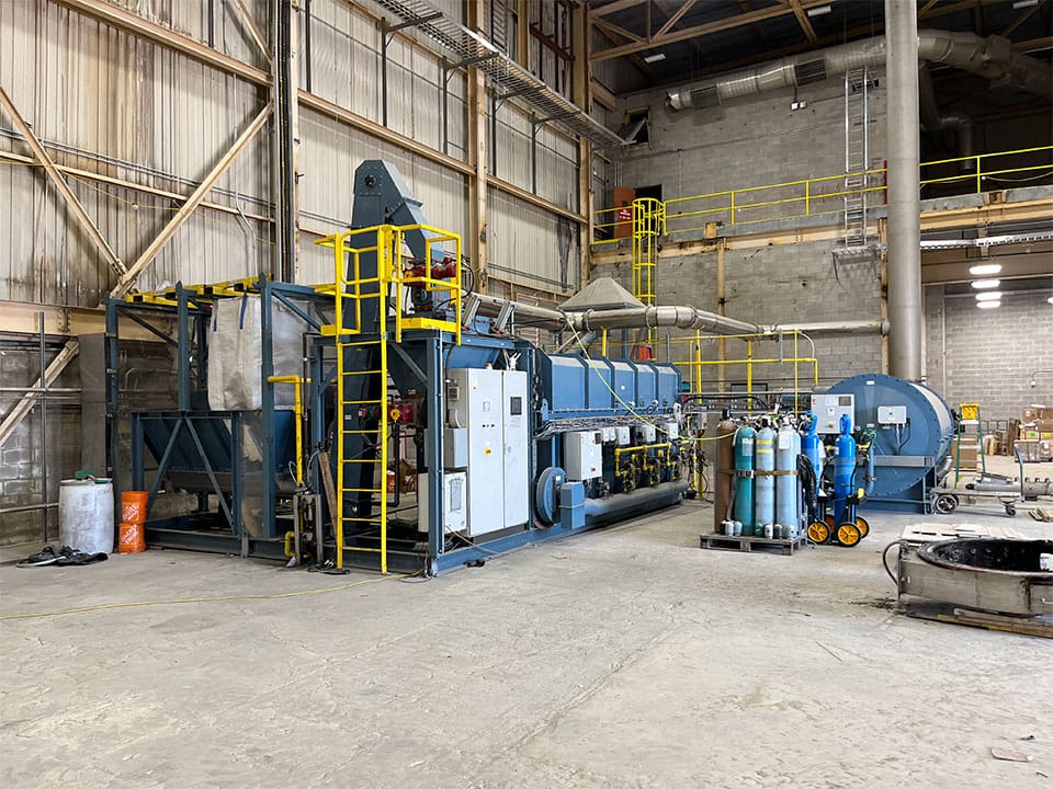 A large machine in the corner of a large warehouse