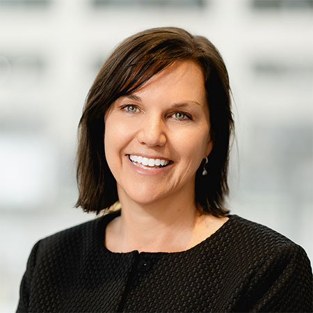 Sally Taylor, a smilling white woman with dark brown hair wearing a matching sweater