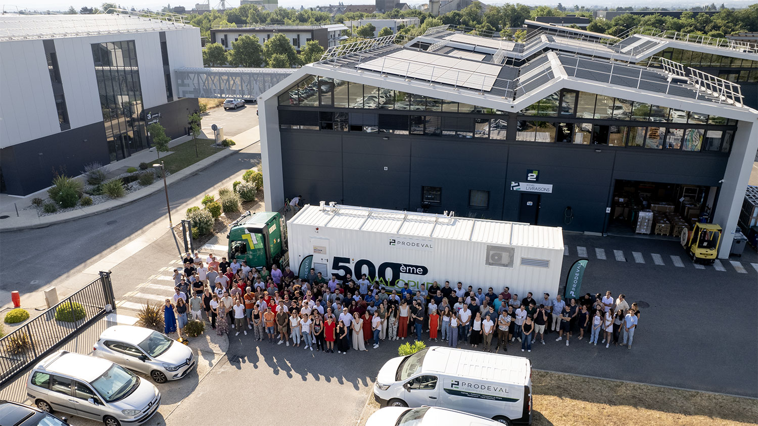 arial view of staff in a parking lot posing for a group photo