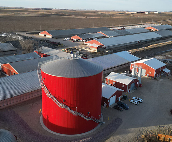 West Branch RNG - Maurice, IAArial view of farm complex with a large tank in the foreground and long buildings in the background.